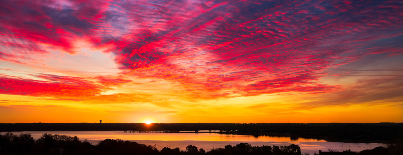 Photo of local yellow, red , and purple sunset over a lake.